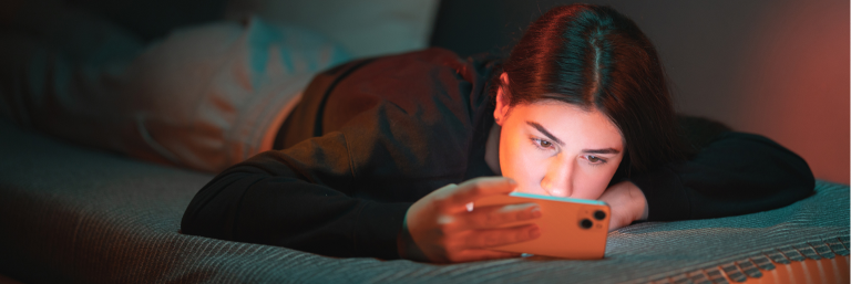 Flicka tittar på mobil